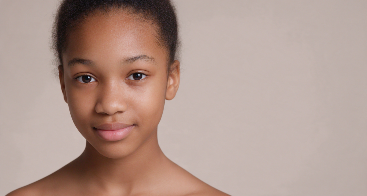 Close portrait of a teenager with healthy, clear skin against a soft studio backdrop