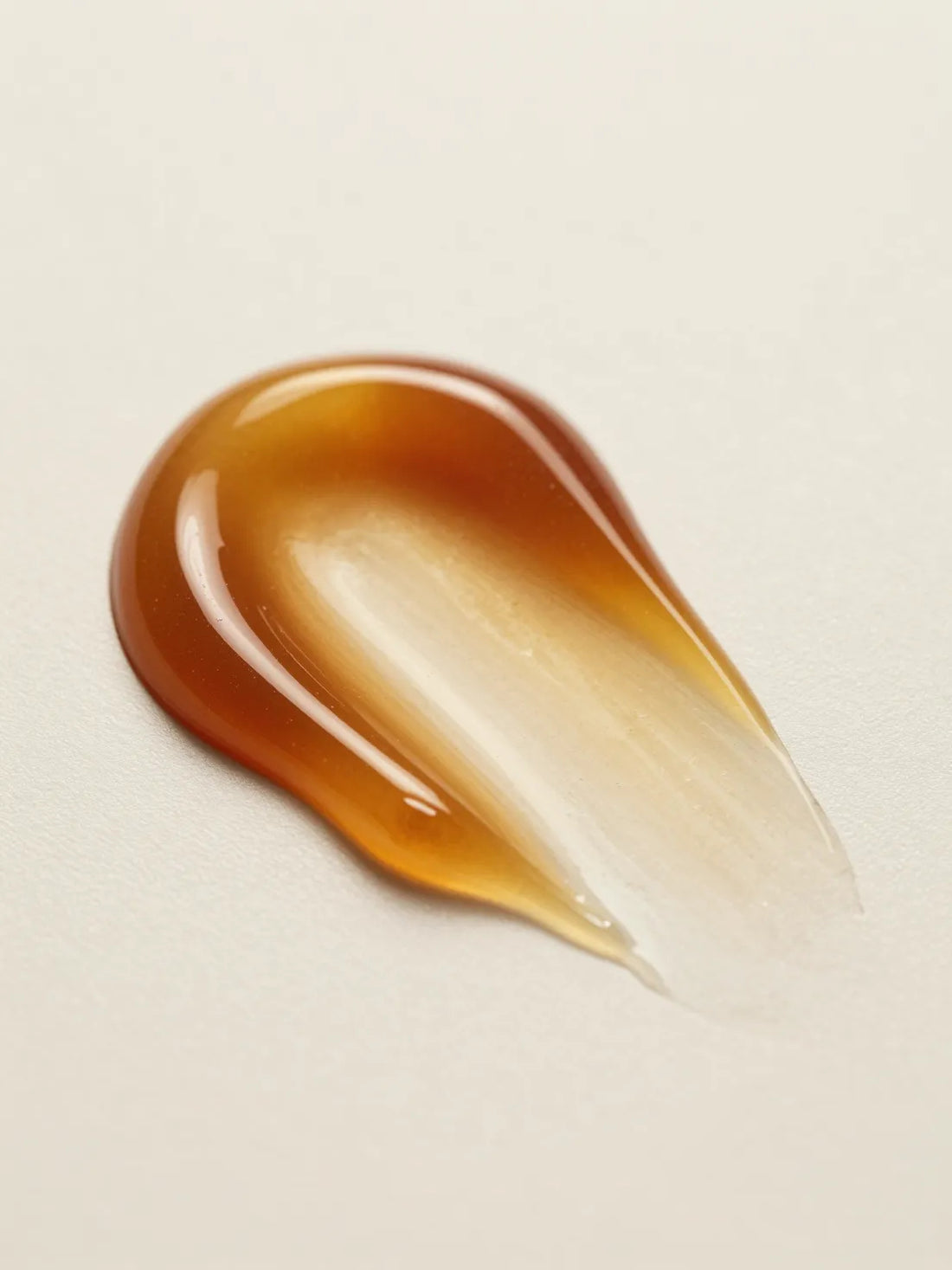 OMEGA-RICH BARRIER FACIAL OIL, the texture of amber facial oil in close macro