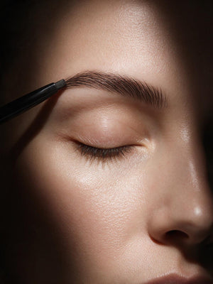 Eyebrow Pencil Dual Tip Angled Spoolie For Beginners in soft black, drawn through the eyebrow