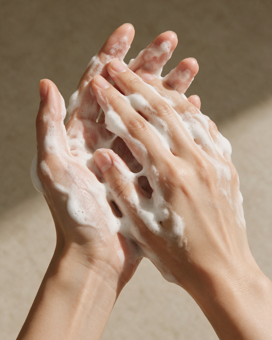 GINGER CARDAMOM BODY WASH worked to a white lather between both hands and lifted to the face, eyes closed.