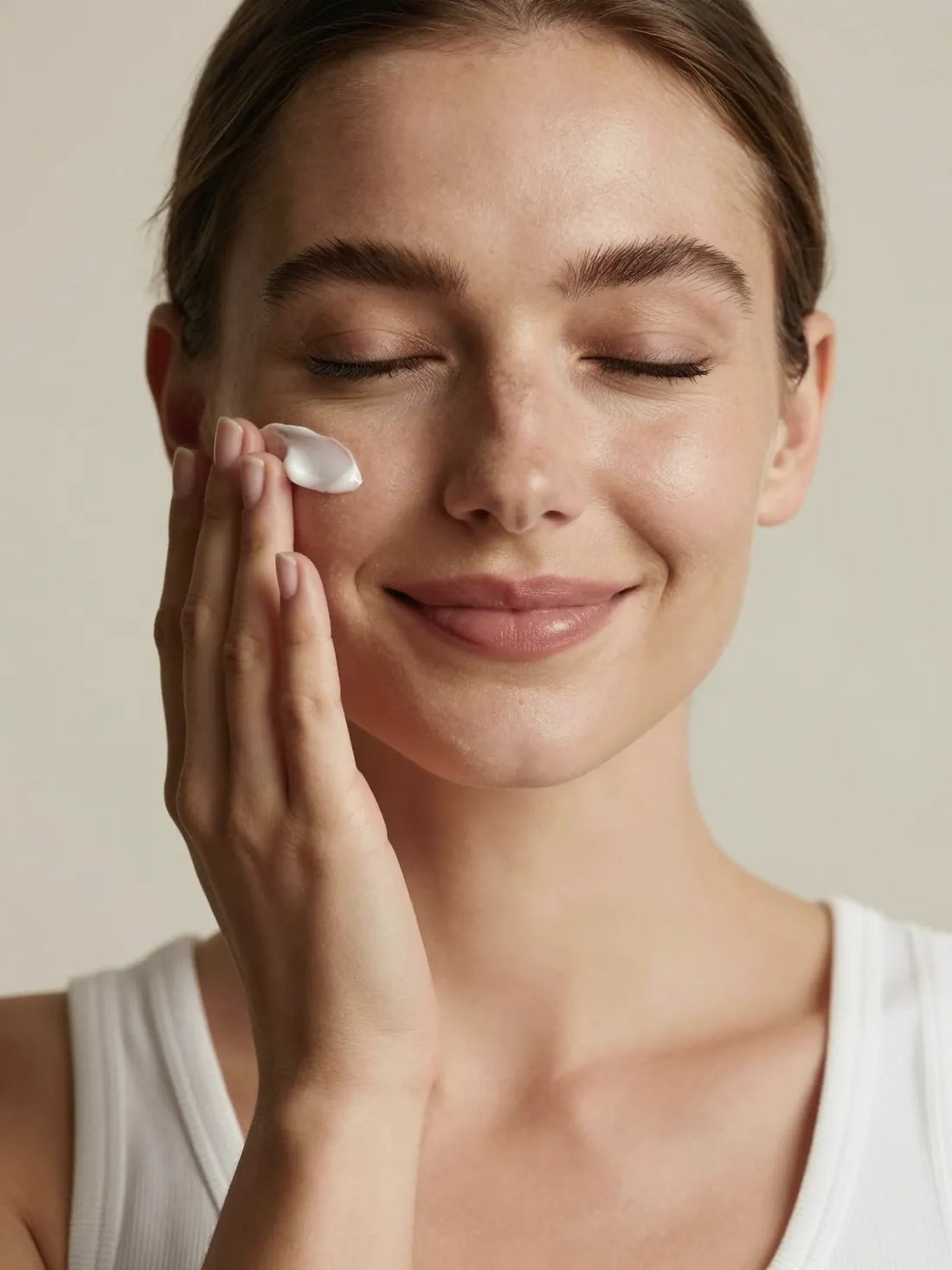 A white cream pressed into the cheekbone with the fingertips, eyes closed, HYDRATION DAY CREAM 15 ML