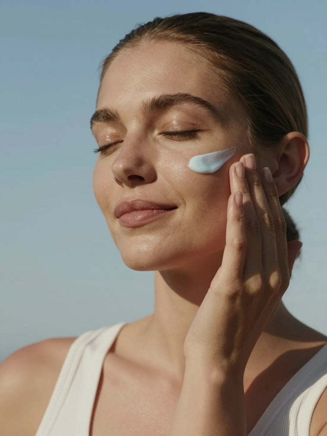 A blue tinted gel pressed into the cheek with the fingertips, eyes closed, ZINC PCA BALANCING GEL