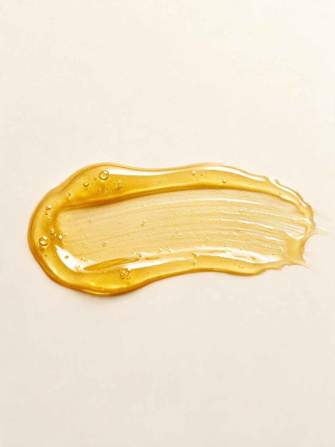 THE RADIANCE BODY OIL, the texture of golden body oil in close macro
