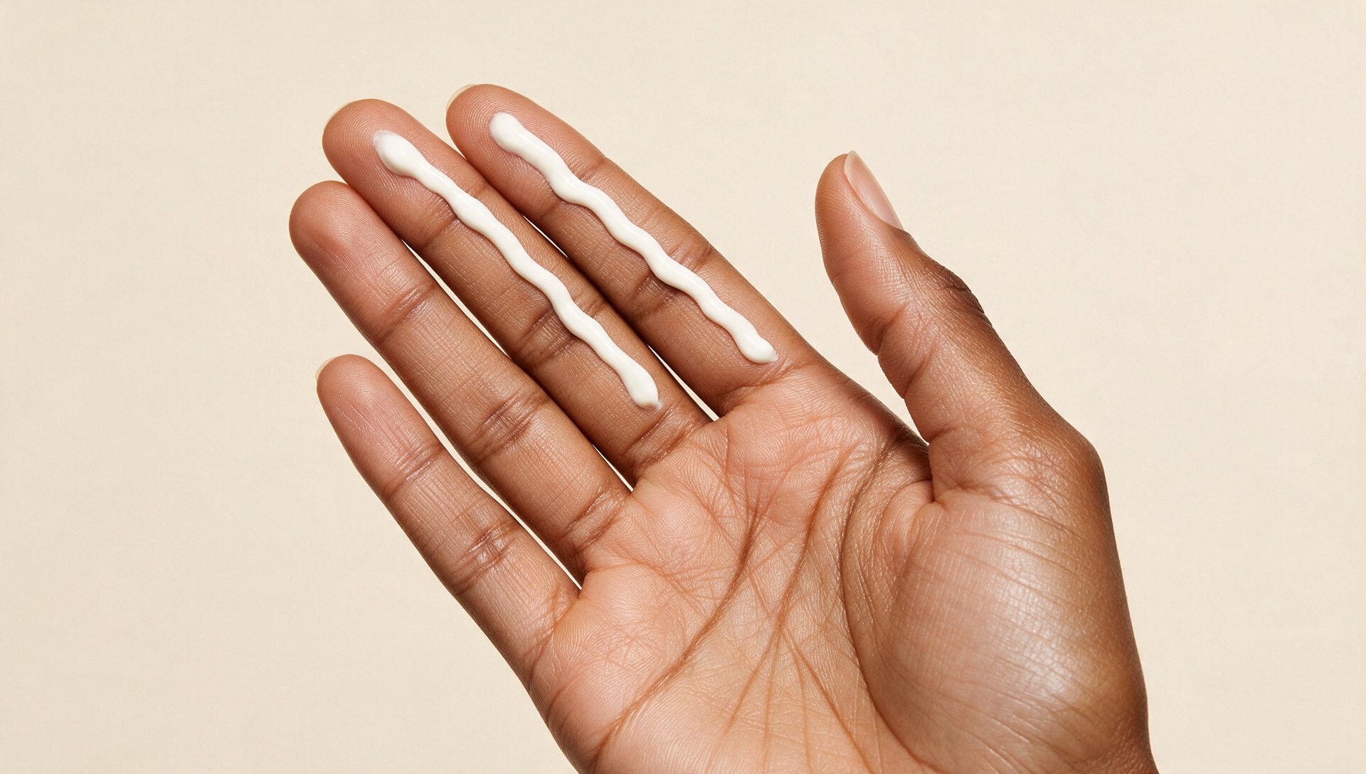 Two lines of sunscreen squeezed along the index and middle fingers, the two-finger rule
